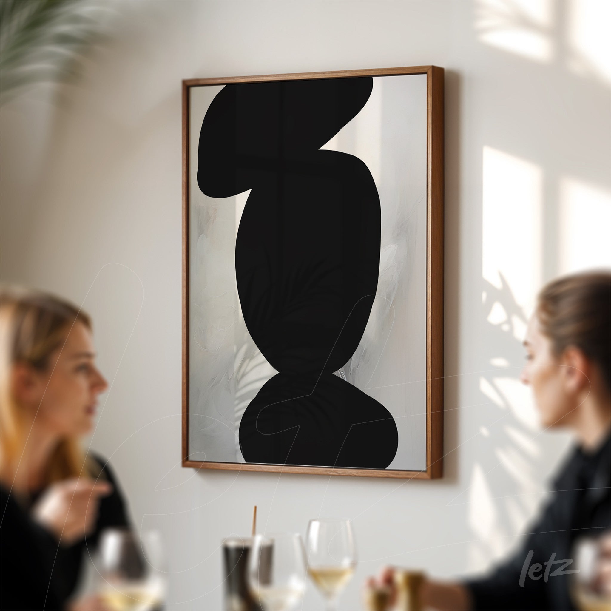 quadro minimalista com formas abstratas em preto sobre fundo claro, emoldurado em madeira
