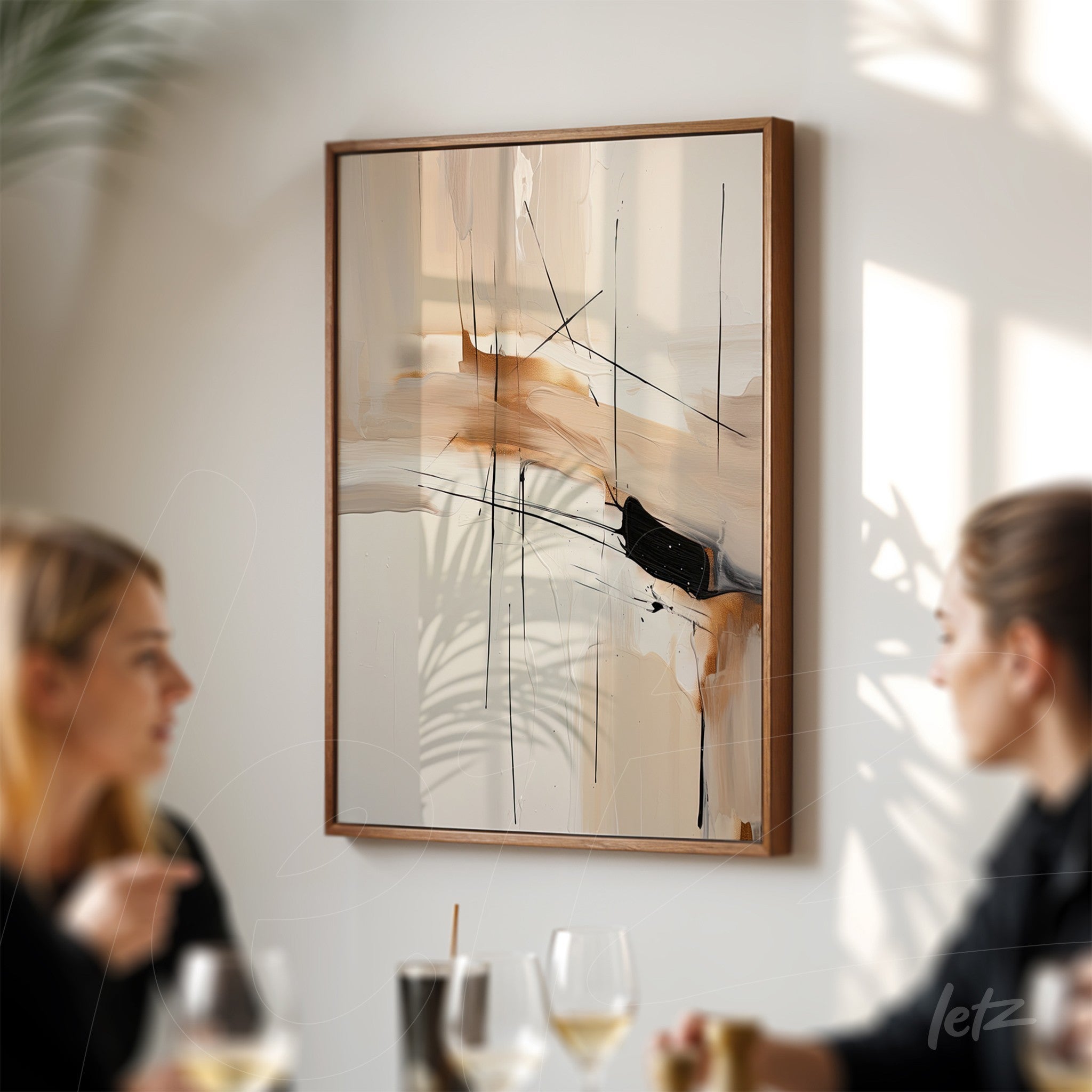 quadro com arte abstrata em tons neutros e linhas pretas, em moldura de madeira clara, exposto em um ambiente com duas pessoas conversando