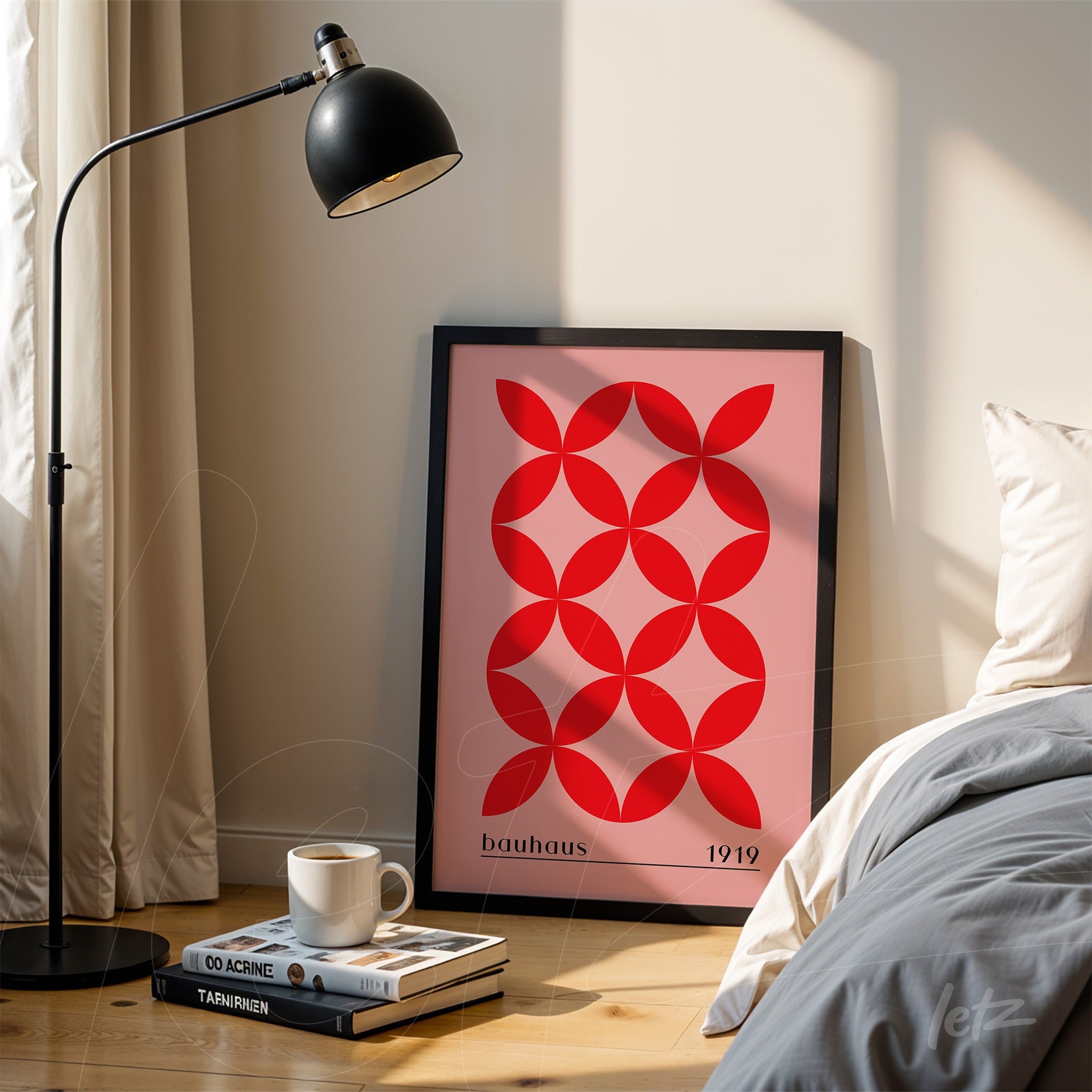 quadro com arte geométrica em vermelho e rosa estilo bauhaus encostado em parede clara com moldura preta
