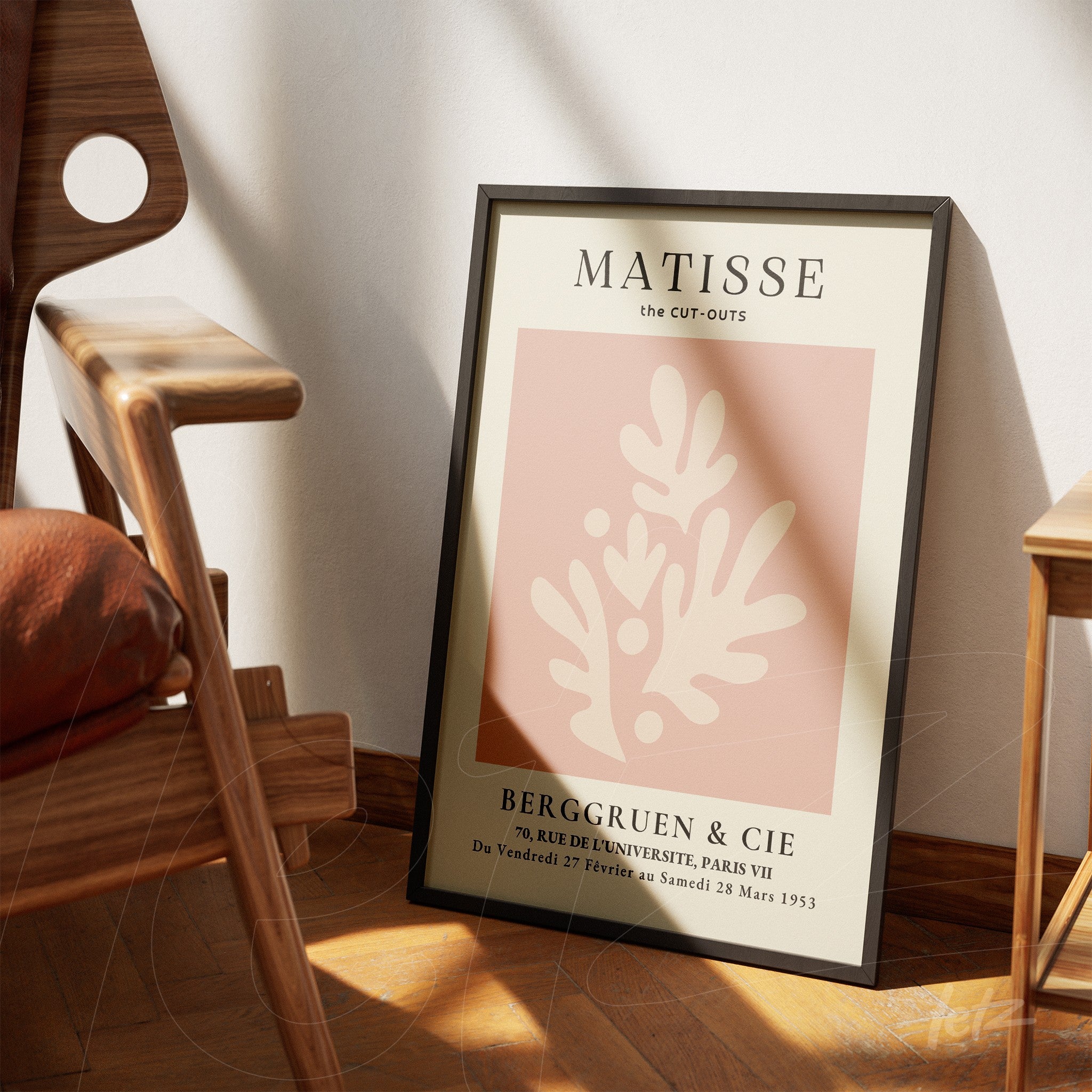 quadro emoldurado com arte inspirada em Matisse, apresentando formas abstratas em fundo rosa suave e tipografia vintage, apoiado ao lado de uma cadeira de madeira