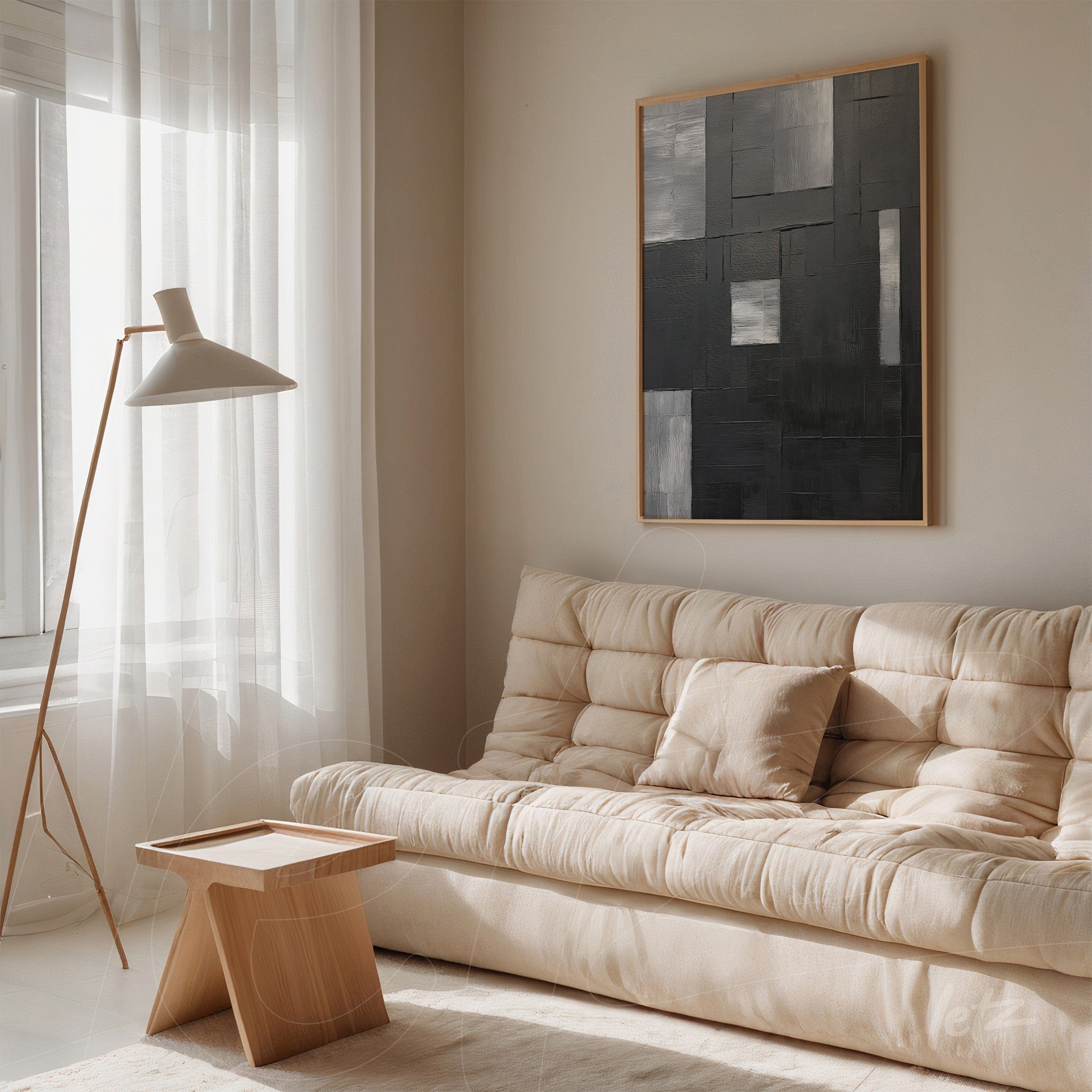quadro abstrato em tons de cinza com moldura clara sobre sofá beige em ambiente minimalista