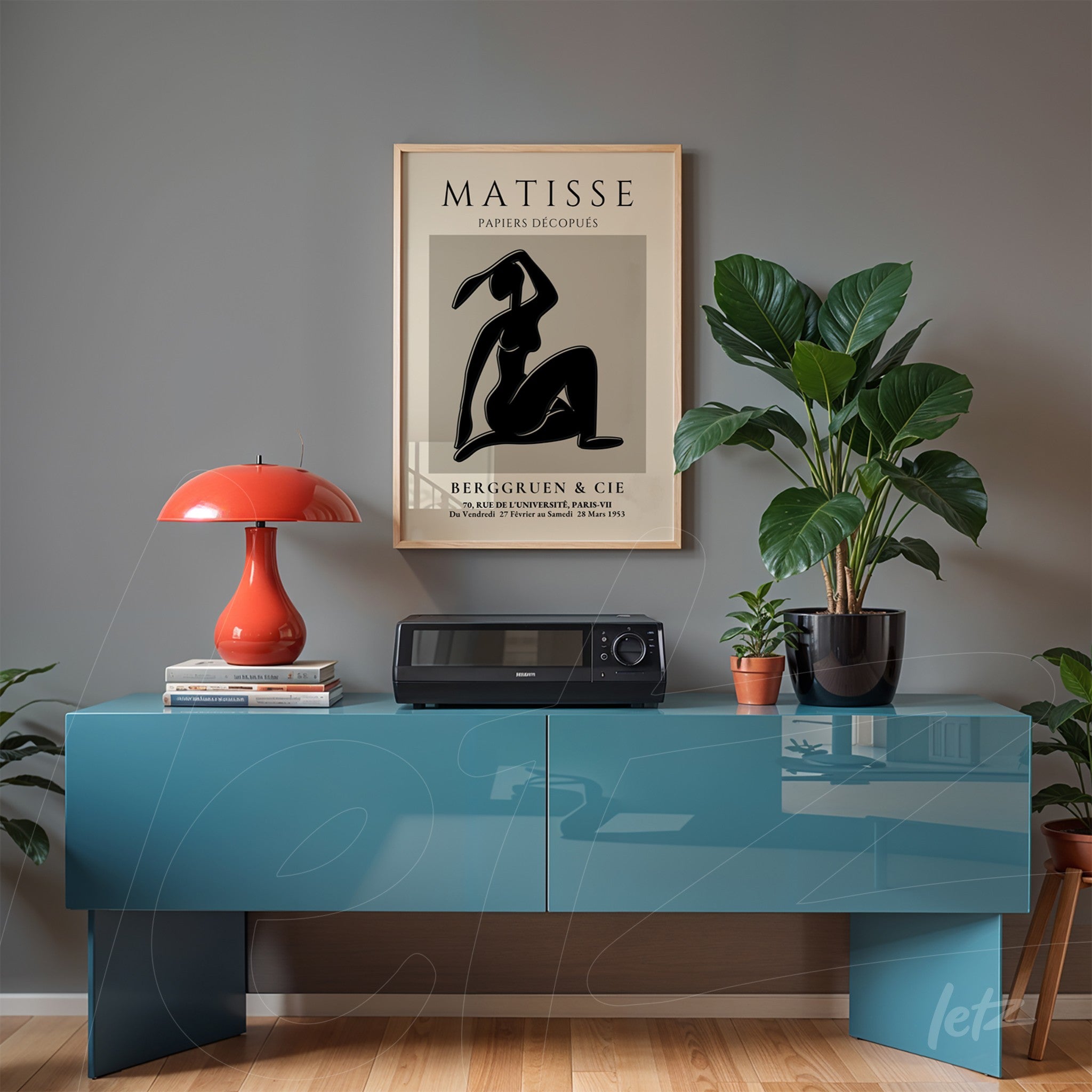 quadro decorativo com arte em silhueta de mulher em moldura clara, exibido em ambiente moderno com mesa azul e planta ao fundo