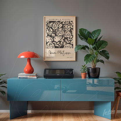quadro decorativo com arte de matisse exibido sobre móvel moderno em tom azul, acompanhado de luminária laranja e plantas