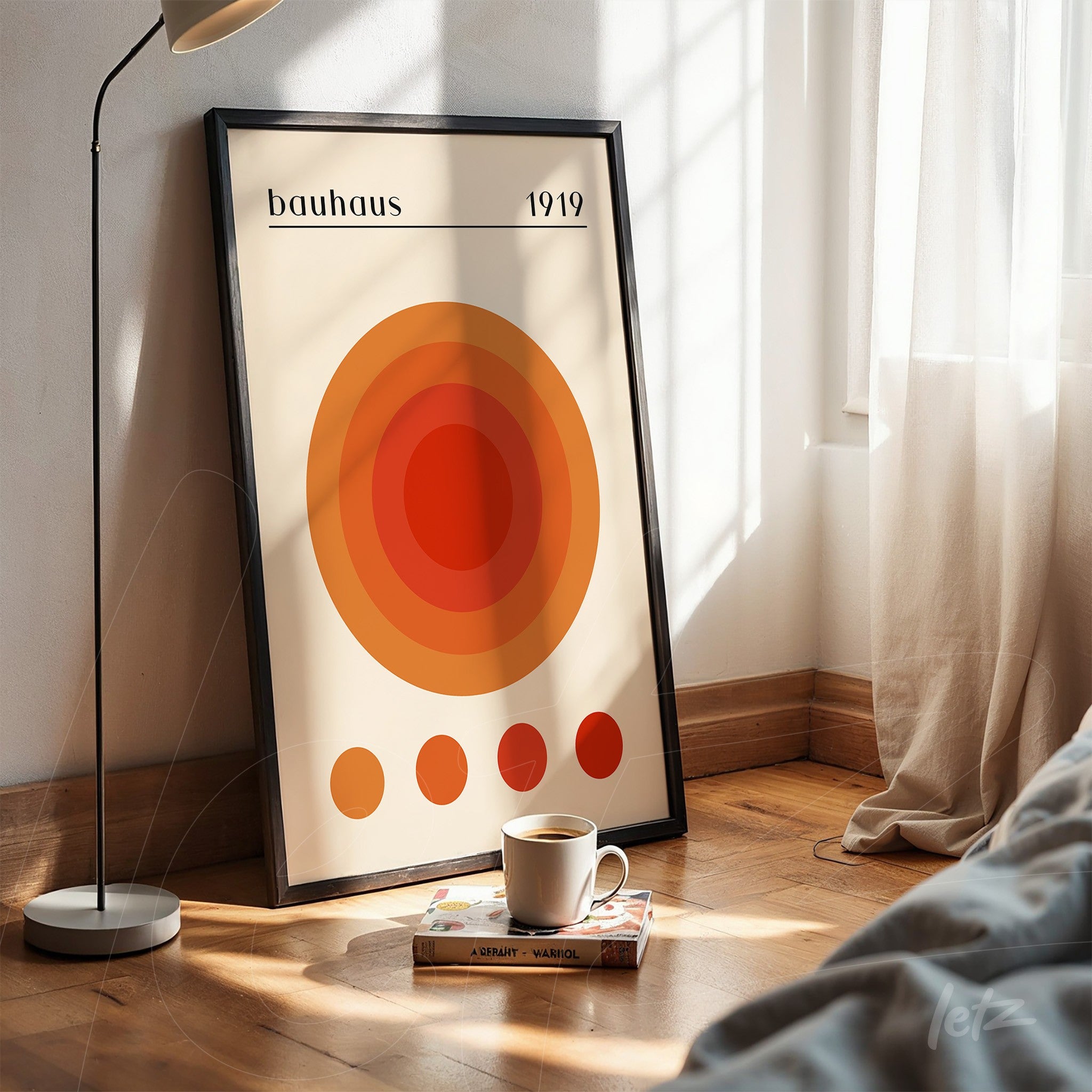 pôster com arte moderna de círculos concêntricos em tons de laranja emoldurado em preto apoiado em piso de madeira