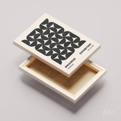 tela em canvas com arte geométrica em preto e branco exibida sobre moldura natural clara