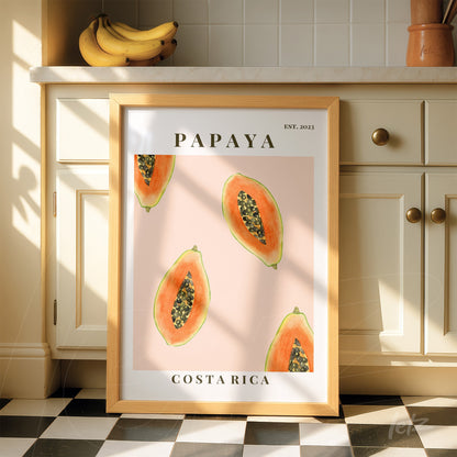 quadro com arte de papaias em fundo rosa, moldura de madeira clara e texto 'PAPAYA' e 'COSTA RICA'
