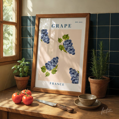 quadro decorativo com ilustração de uvas em fundo claro, moldura de madeira, apoiado em mesa de madeira com tomates e ervas