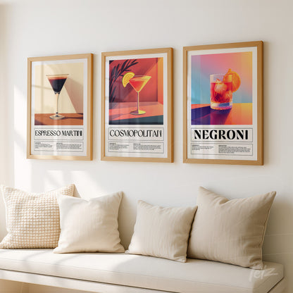 composição com três quadros decorativos de drinks em moldura dourada, incluindo espesso martini, cosmopolitan e negroni, sobre parede clara