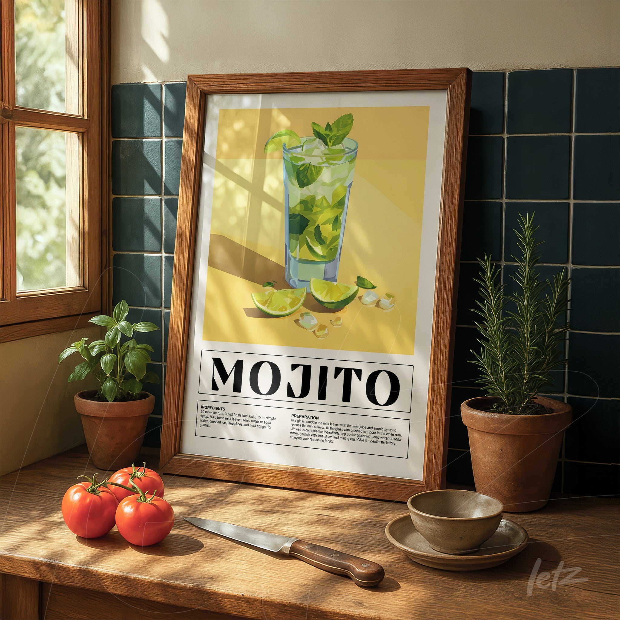quadro com arte retrô do drink mojito em moldura de madeira clara sobre mesa de madeira, ao lado de tomate e ervas em vasos
