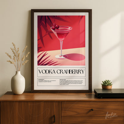 quadro com arte retrô de drink vodka cranberry em moldura escura sobre mesa de madeira