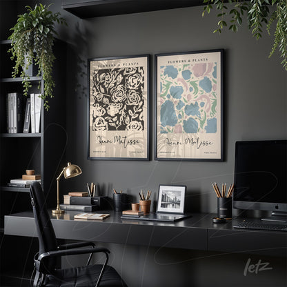composição com dois quadros decorativos de flores em moldura preta, um com fundo escuro e floral em relevo, e outro com fundo claro e flores em tons pastéis, ambos exibidos em um ambiente moderno com prateleiras e luminária de mesa