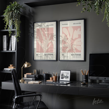 composição de dois quadros decorativos com arte minimalista de Matisse em molduras pretas expostos sobre mesa de escritório com plantas