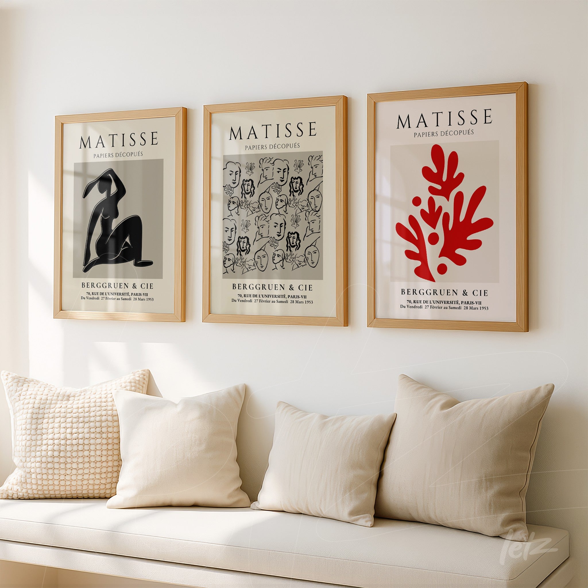 composição de três quadros decorativos com ilustrações de Matisse em molduras de madeira clara, exibidos sobre uma parede branca e apoiados em um sofá com almofadas claras