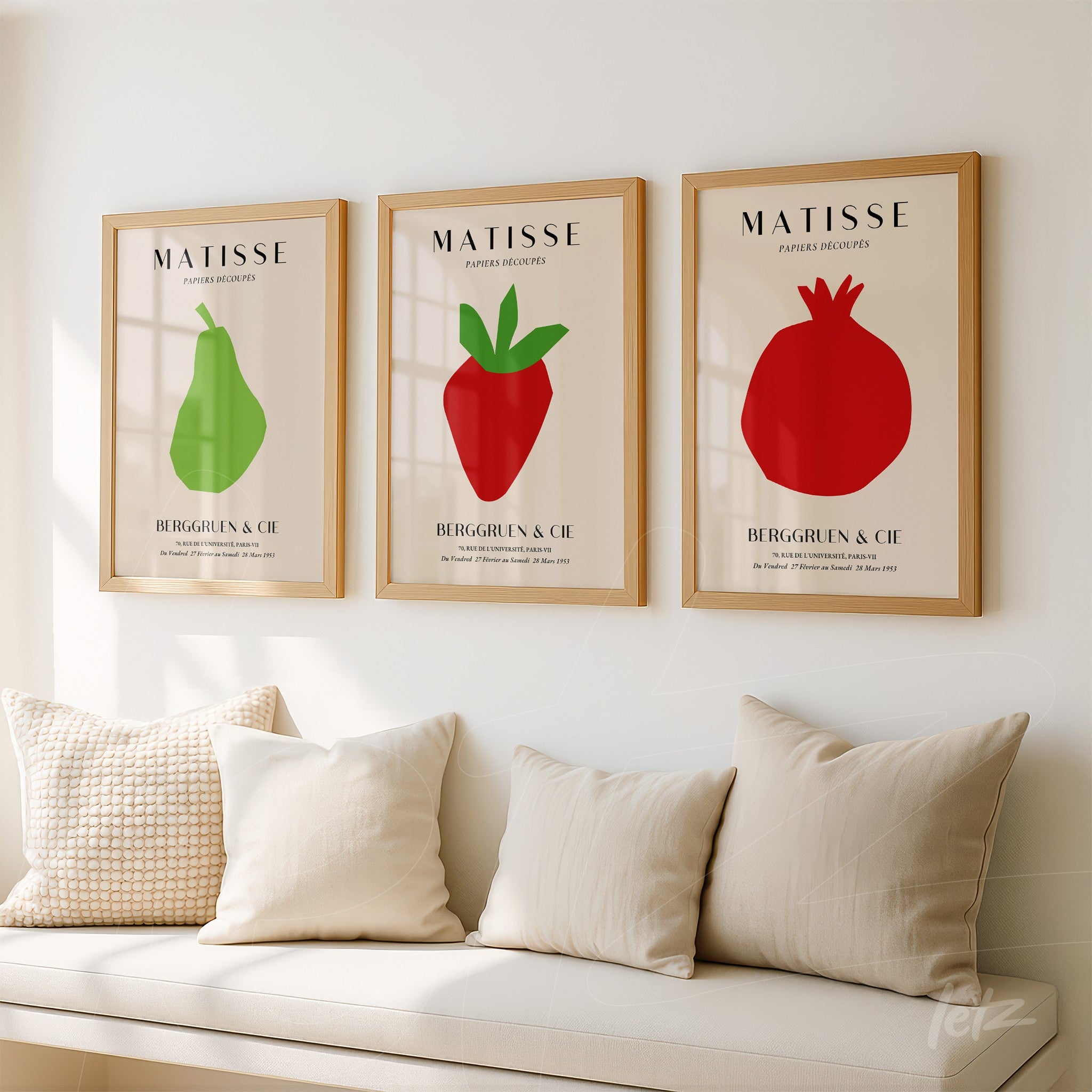 série de quadros com ilustrações minimalistas de frutas em moldura de madeira clara, apresentando uma pera verde, um morango vermelho e uma romã na parede clara