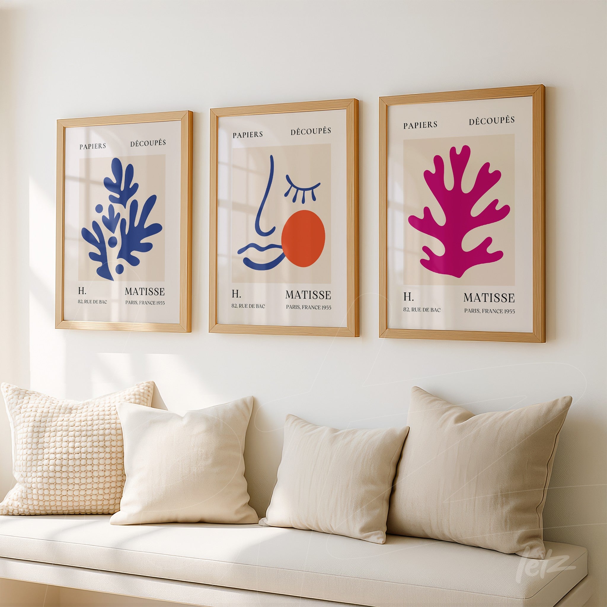 composição de três quadros decorativos com cores vibrantes em moldura de madeira clara, apresentando formas abstratas de corais e uma face estilizada com fundo claro
