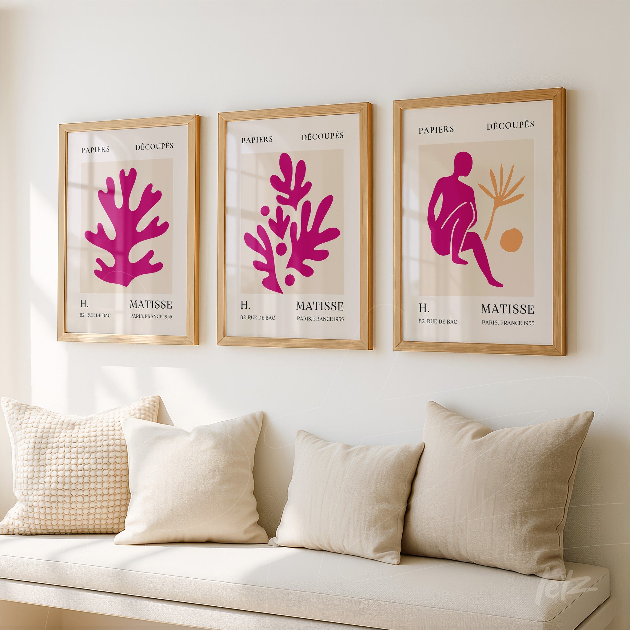 composição de três quadros decorativos com recortes coloridos em moldura de madeira clara sobre parede neutra