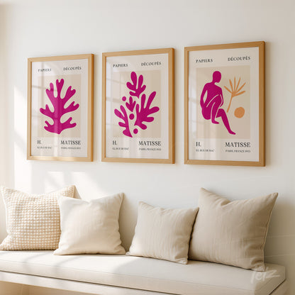 composição de três quadros decorativos com recortes coloridos em moldura de madeira clara sobre parede neutra