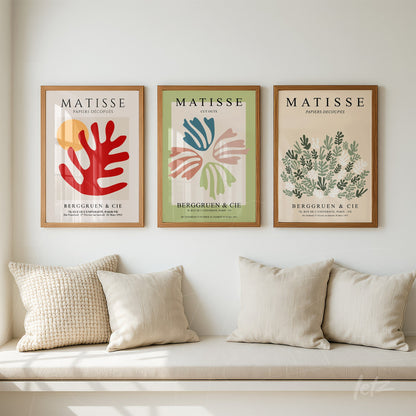 composição de três quadros decorativos em moldura de madeira clara com design inspirado em Matisse sobre parede branca