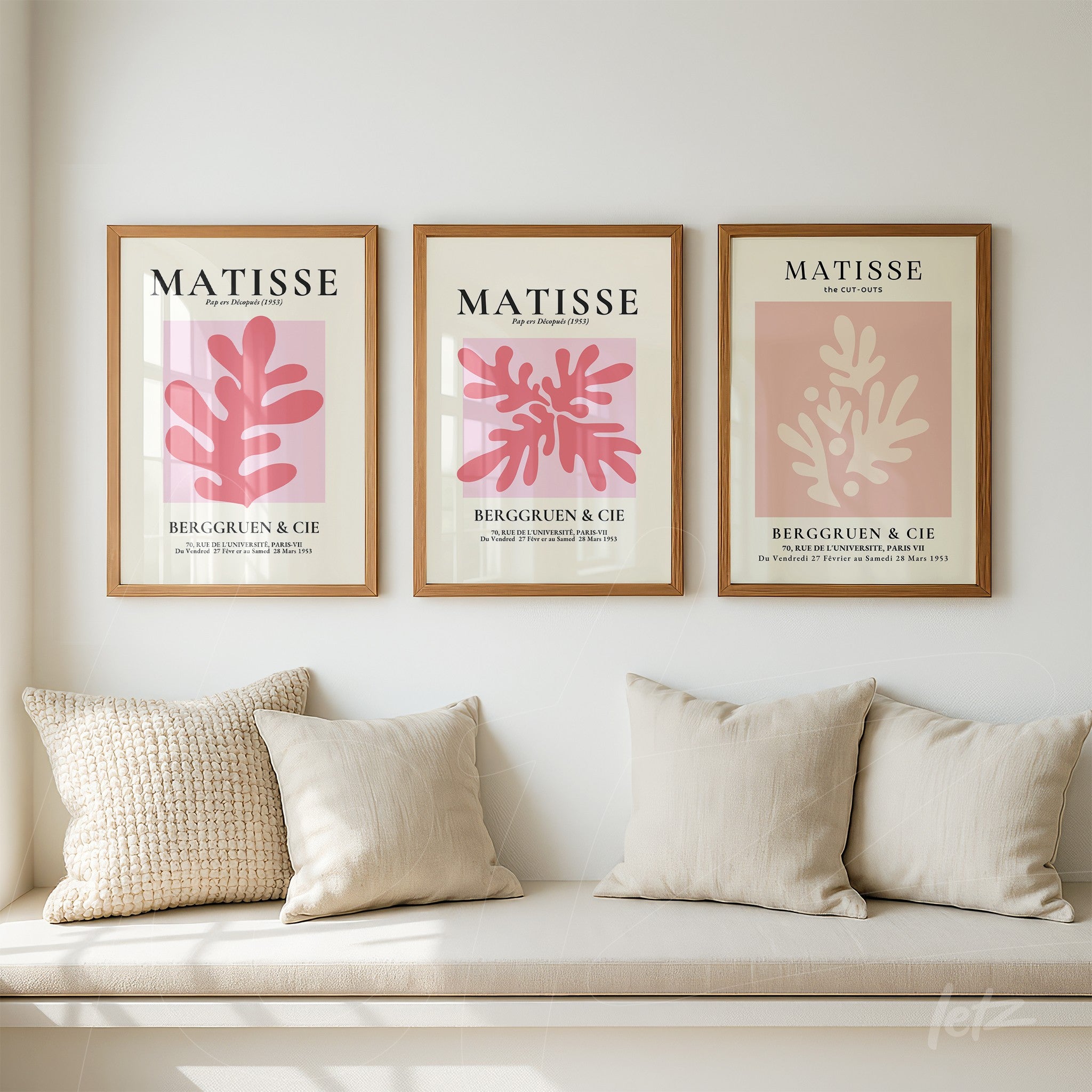 composição com três quadros em moldura de madeira clara, apresentando ilustrações abstratas em tons de rosa e creme com elementos botânicos