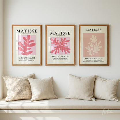 composição com três quadros em moldura de madeira clara, apresentando ilustrações abstratas em tons de rosa e creme com elementos botânicos