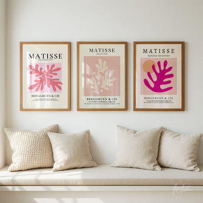 composição de quadros com arte inspirada em Matisse em molduras de madeira clara, apresentando formas botânicas em tons de rosa e marrom sobre fundo em tons neutros