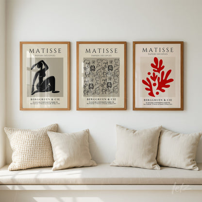 composição de três quadros em moldura de madeira clara com artes de Henri Matisse sobre o fundo claro da parede, apresentando uma figura abstrata, uma série de rostos e um desenho de coral vermelho