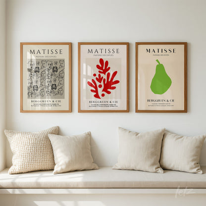 composição de três quadros na parede com molduras de madeira clara, apresentando arte inspirada em Matisse com estampas em cores vermelha, verde e cinza