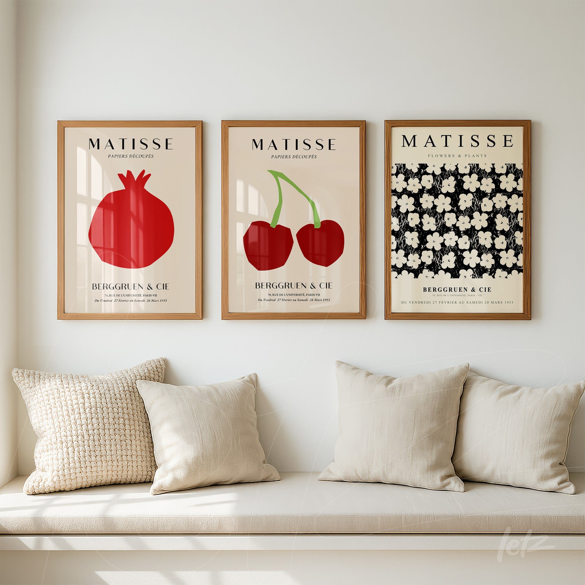 composição com três quadros decorativos emoldurados em madeira clara, com ilustrações botânicas de romã, cerejas e flores brancas sobre fundo escuro