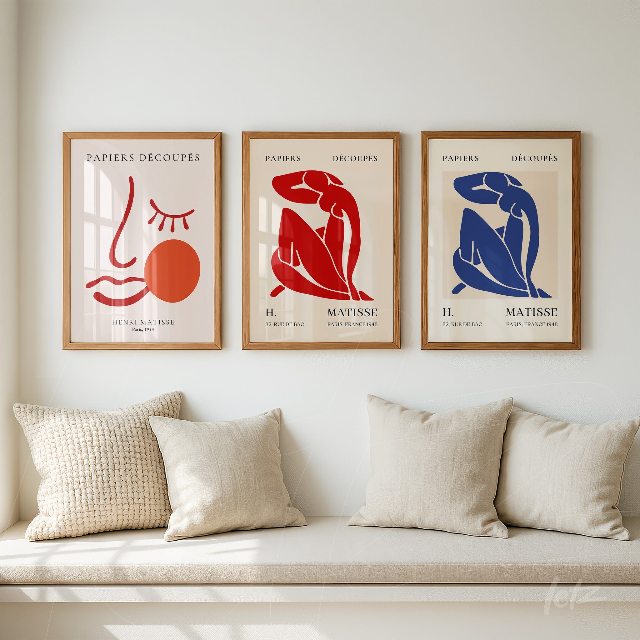 três quadros decorativos em moldura de madeira clara com ilustrações inspiradas em Matisse, apresentando formas abstratas e cores vermelha, azul e terracota em fundo claro