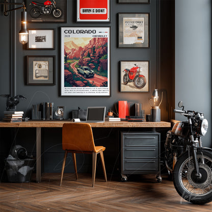 composição de quadros em parede cinza com tema automobilístico, incluindo arte de uma paisagem do Colorado e fotos de motos vintage, ao lado de uma mesa de madeira clara com cadeira de couro e uma motocicleta clássica