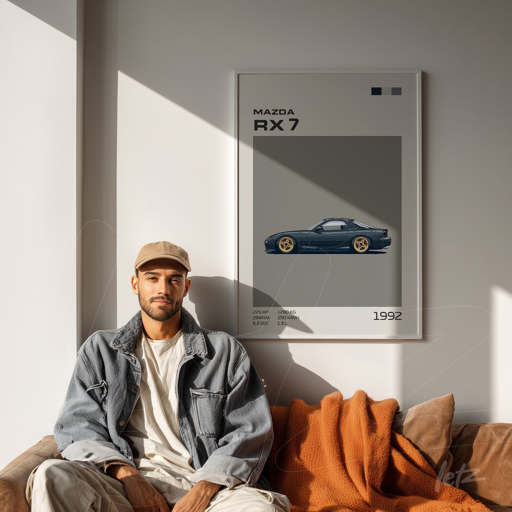 quadro com ilustração de carro Mazda RX-7 em moldura branca, exposto em parede clara ao lado de homem sentado com jaqueta jeans