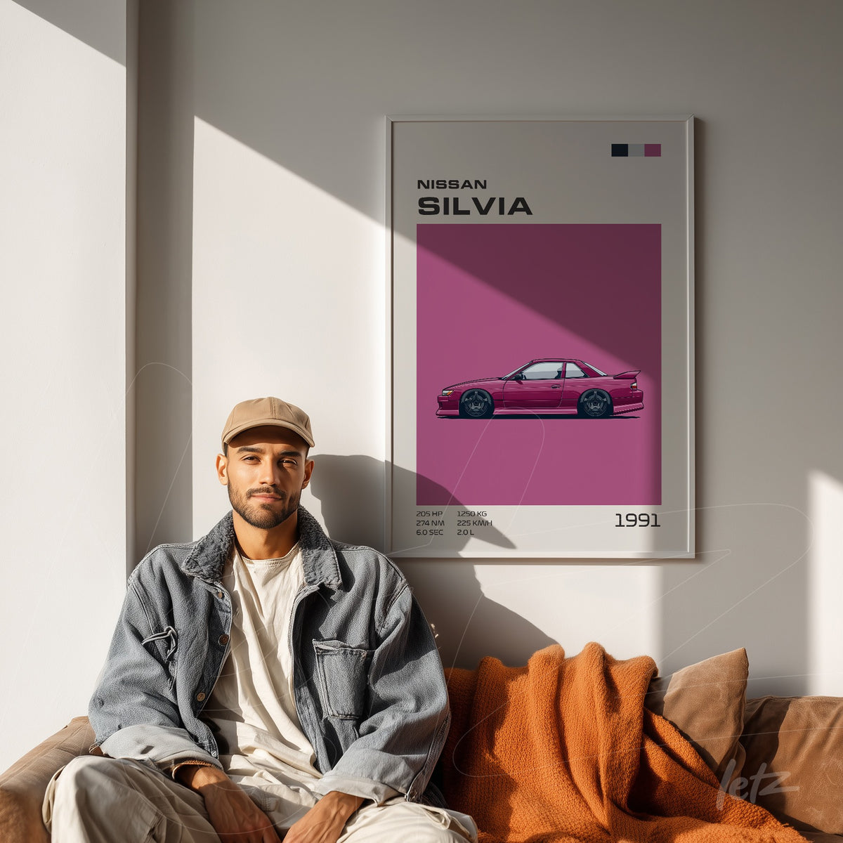 quadro decorativo com ilustração do carro Nissan Silvia em moldura branca, exibido em ambiente moderno com sofá marrom e manta laranja