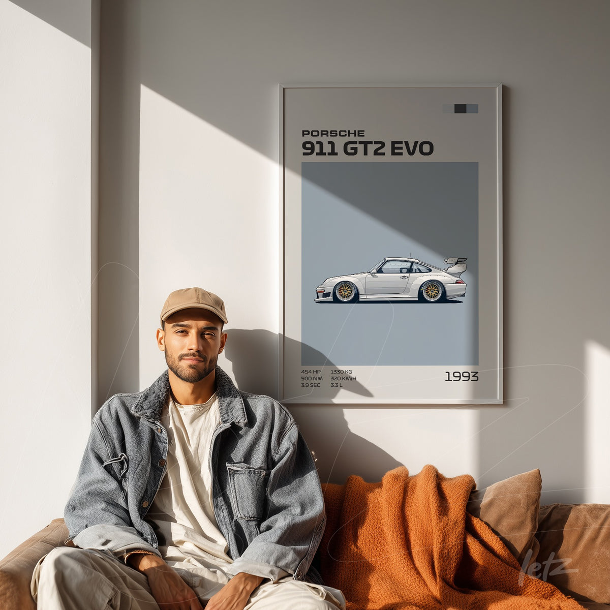 quadro com arte do modelo Porsche 911 GT2 EVO em moldura clara na parede, com um homem sentado em sofá de couro