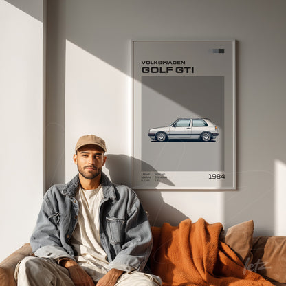 quadro emoldurado com arte digital de um Volkswagen Golf GTI em tons de cinza e azul, exibido sobre parede clara ao lado de um homem sentado no sofá