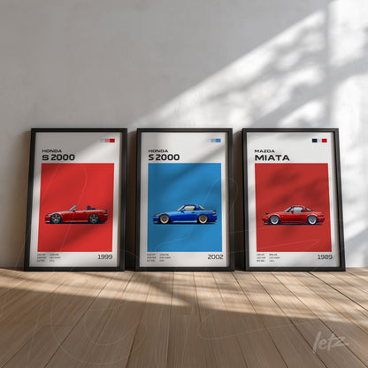 série de quadros com ilustrações de carros clássicos, incluindo Honda S2000 em vermelho e azul, expostos sobre uma parede clara