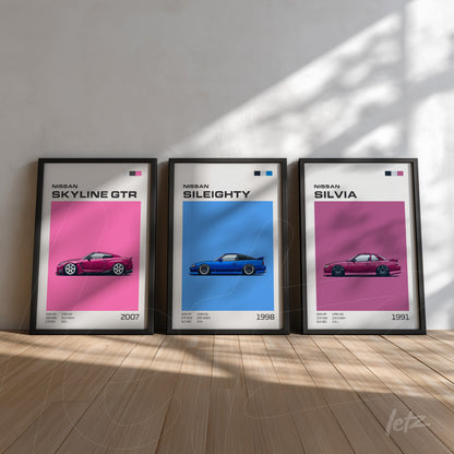 composição de quadros decorativos com ilustrações de carros Nissan em molduras pretas, apresentando os modelos Skyline GTR, Sil80 e Silvia em fundo rosa e azul