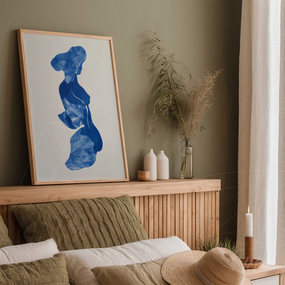 quadro em moldura clara com arte abstrata em azul exibido sobre cabeceira de cama em ambiente de decoração minimalista