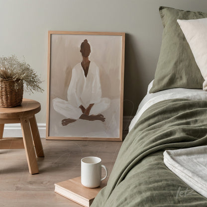 quadro com arte minimalista de figura meditando em moldura de madeira clara sobre cabeceira de cama com roupa de cama em tons de verde