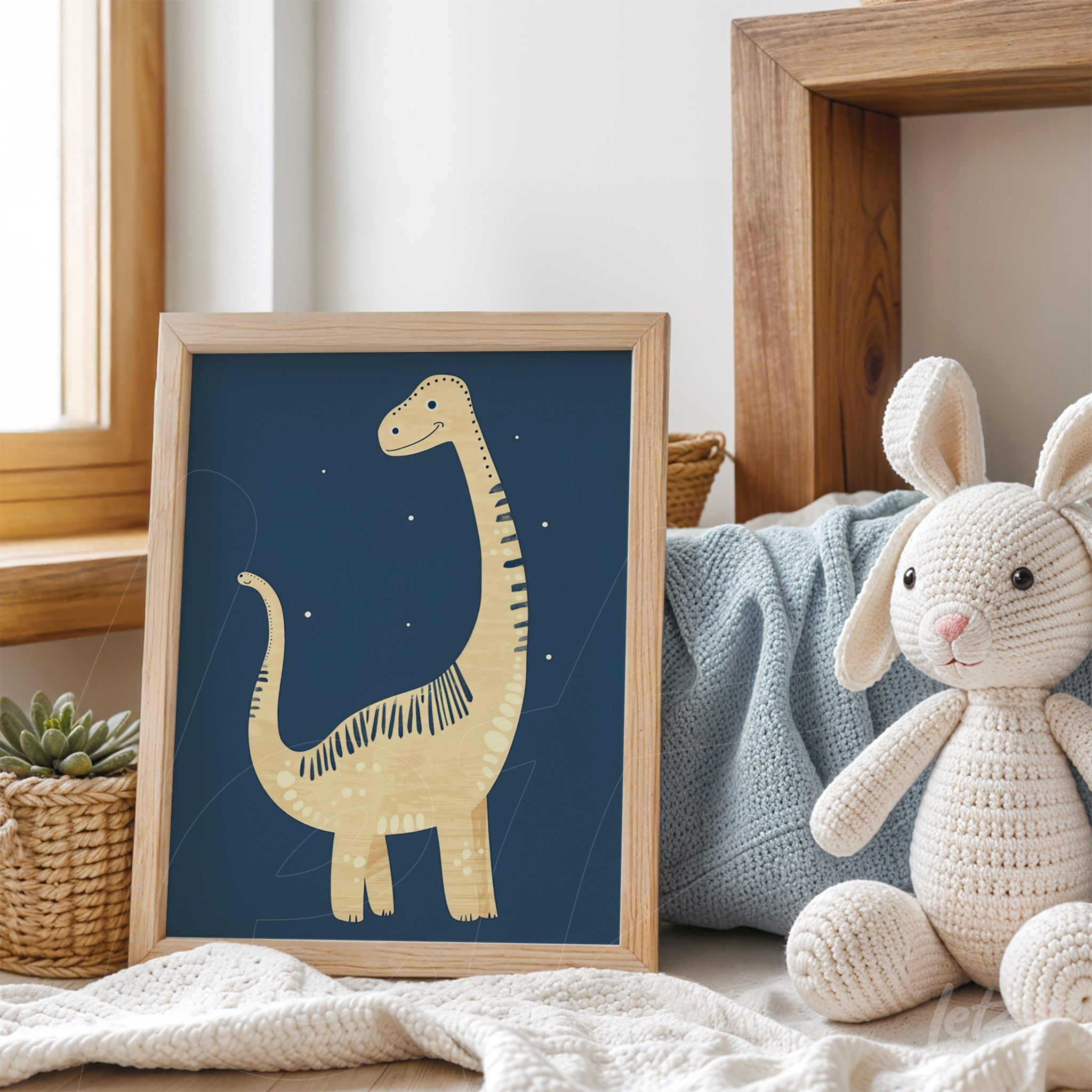 quadro com ilustração de dinossauro em moldura de madeira clara sobre mesa com brinquedo de coelho