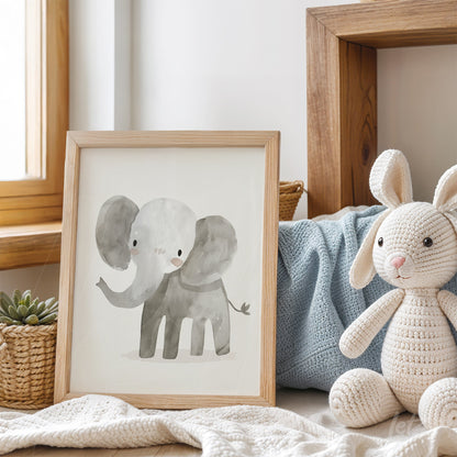 quadro com ilustração de elefante estilizado em moldura de madeira clara, posicionado sobre mesa com brinquedo de coelho e manta azul