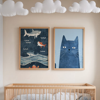 dupla de quadros com ilustrações infantis, um com tubarões nadando sobre um fundo azul e outro com um gato azul em moldura de madeira clara