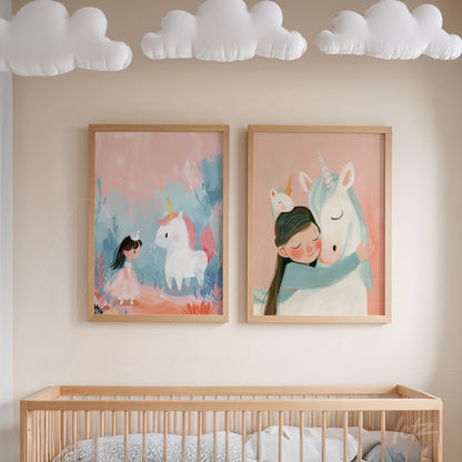 quadro em moldura de madeira clara com ilustração de menina abraçando um unicórnio ao lado de outro quadro com personagem infantil e unicórnio em fundo pink