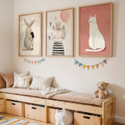 composição com três quadros infantis em moldura de madeira clara, apresentando um coelho, um gato com a coroa e um gato sentado, exibidos em parede clara ao lado de um banco de madeira com almofadas coloridas
