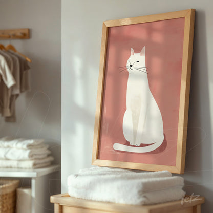 quadro com ilustração minimalista de um gato branco sobre fundo rosa, moldura de madeira clara, apoiado em um móvel em ambiente doméstico