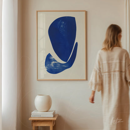 quadro em moldura clara com arte abstrata em azul sobre fundo branco, exposto em parede de ambiente minimalista