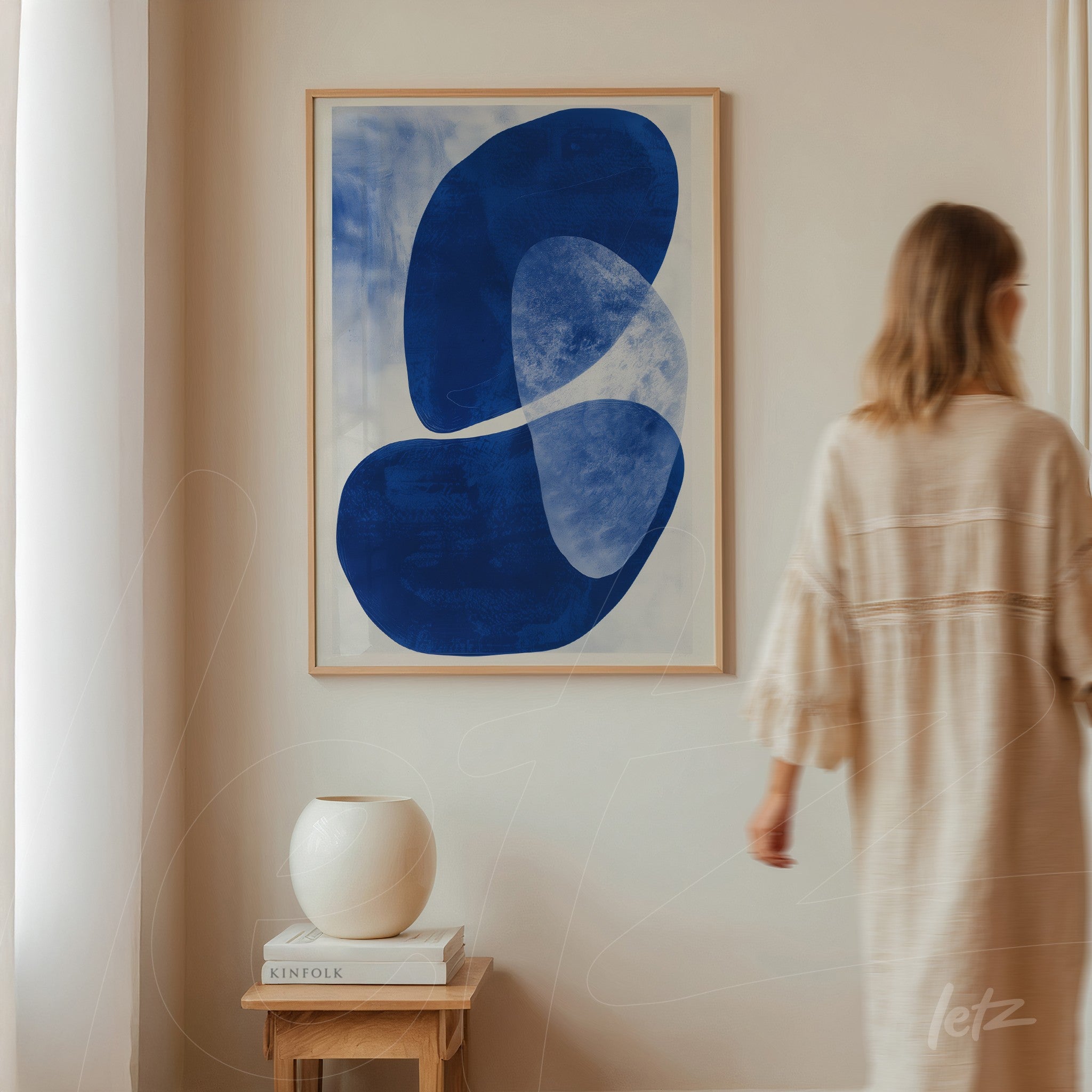 quadro com arte abstrata em azul marinho em moldura clara sobre parede neutra