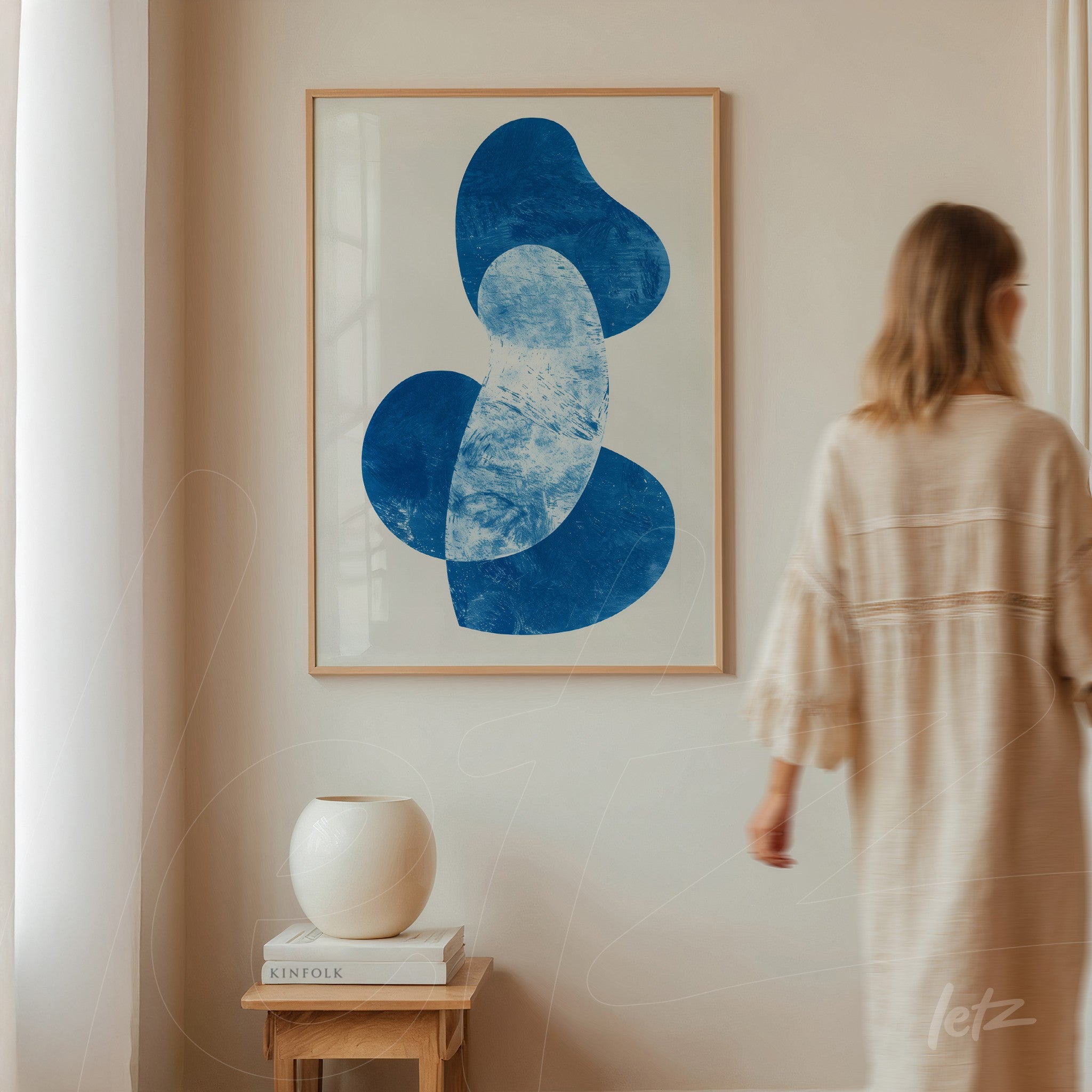 quadro moderno com formas abstratas em azul em moldura clara sobre parede neutra