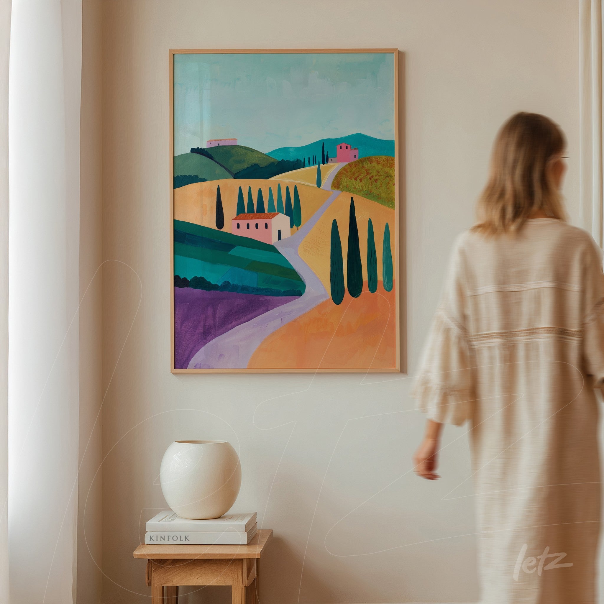 quadro grande com paisagem vibrante de colinas e ciprestes em moldura de madeira clara exibido em parede neutra