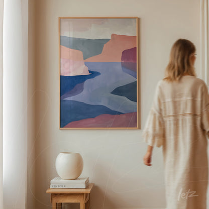 quadro em estilo abstrato de paisagem com forma fluida em moldura de madeira clara exibido em uma parede neutra