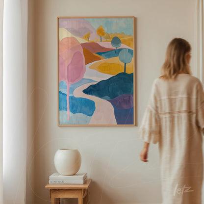 quadro com paisagem abstrata em tons pastel, com árvores em diferentes cores e um rio sinuoso, moldura de madeira clara, exposto em uma parede clara